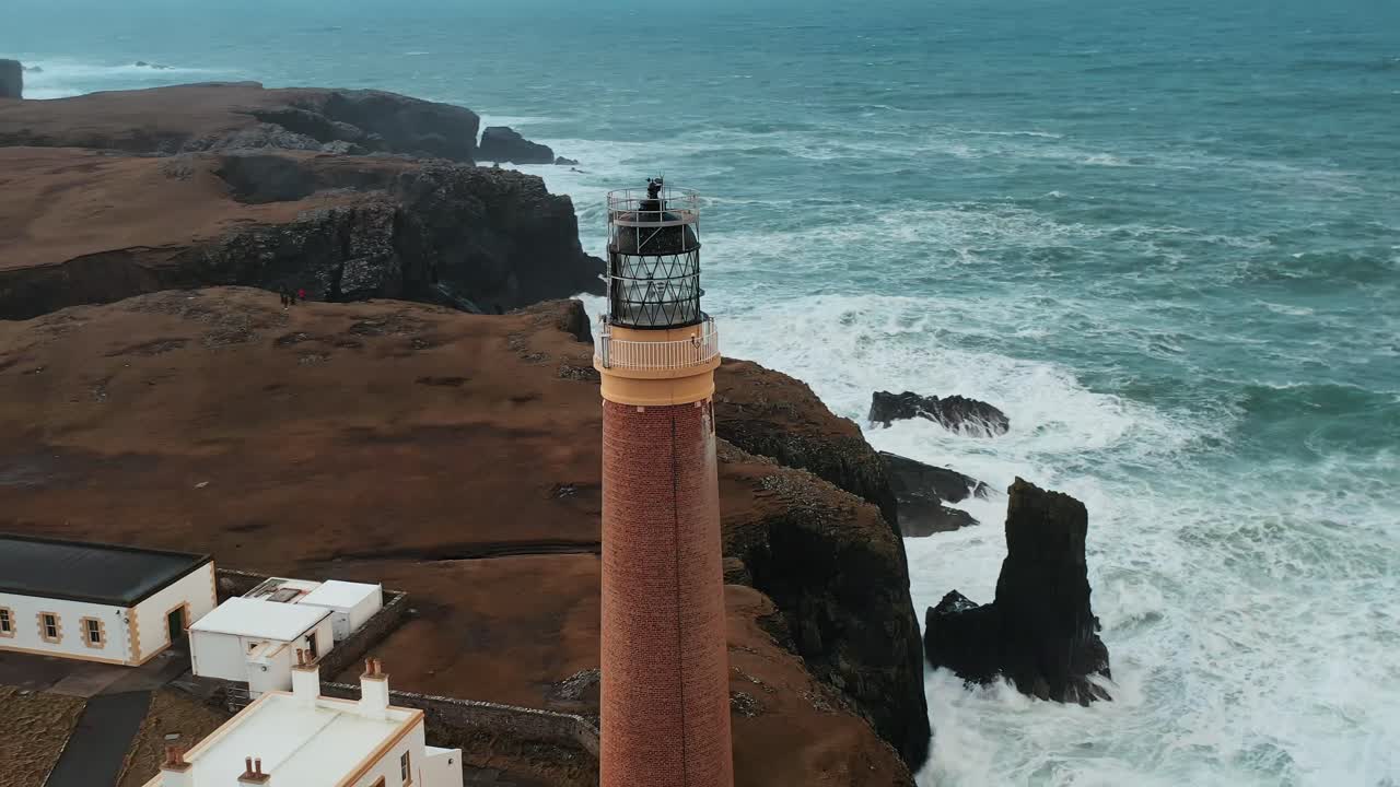 Ripresa aerea intorno al Faro di Ness, con onde atlantiche impetuose.