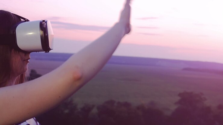 Donna che sperimenta la realtà virtuale al tramonto