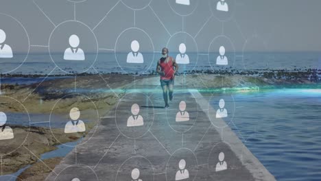 animation of network of connections over senior african american man running at beach