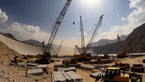 large-scale dam construction site with multiple cranes and heavy machinery
