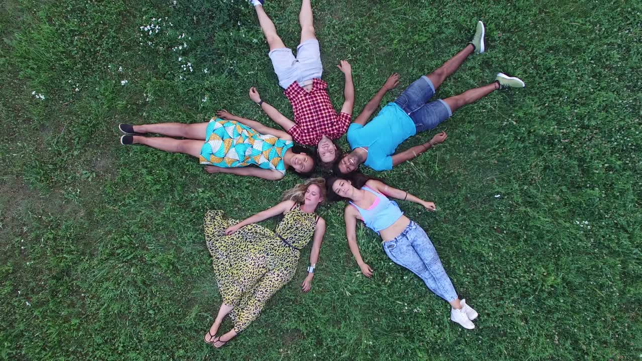 잔디에 누워있는 별 모양을 형성하는 친구 그룹의 안테나