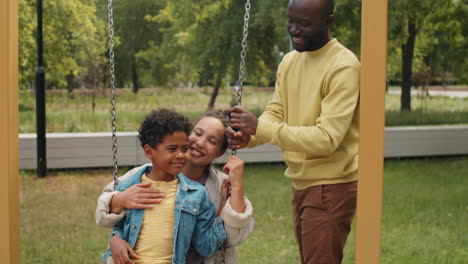 Afroamerikanischer-Junge-Schaukelt-Mit-Seiner-Mutter-Auf-Einem-Familienspaziergang-Im-Park