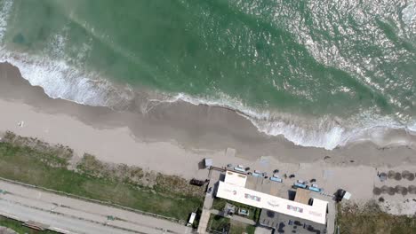 Blick-Von-Oben-Auf-Die-Wellen,-Die-Am-Sandstrand-In-Vama-Veche,-Rumänien,-Plätschern-–-Drohnenaufnahme