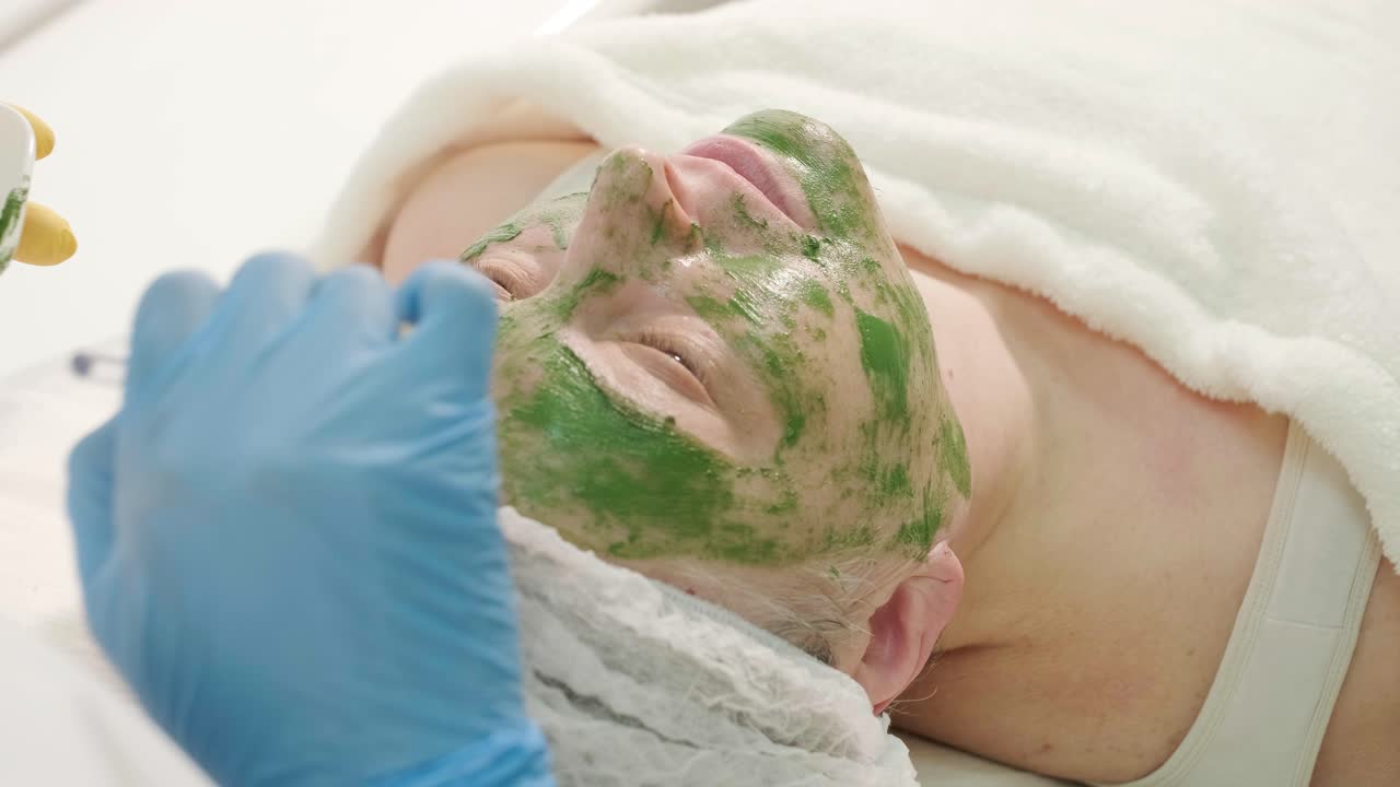 현대 화장품 클리닉에서 전문적인 얼굴 관리 절차. 얼굴 마스크 적용