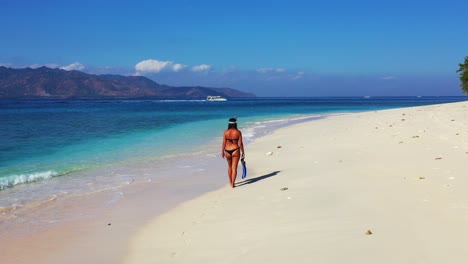 Frau-In-Einem-Verführerischen-Mini-Bikini-Mit-Schnorchelmaske-Und-Flossen,-Die-Am-Strand-Entlang-Spaziert