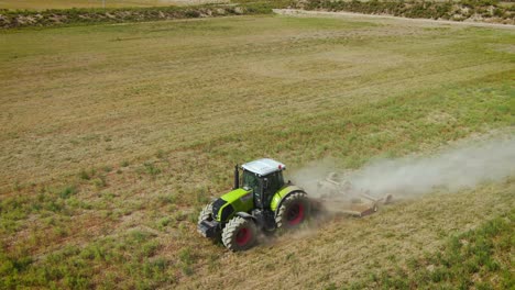 Tractor-Mows-The-Grass-On-An-Agricultural-Field-In-Almaty,-Kazakhstan---aerial-drone-shot