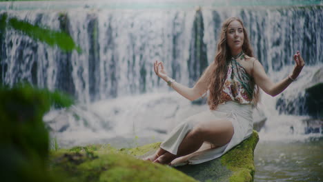 mujer meditando frente a una cascada