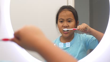 una chica cepillándose los dientes.