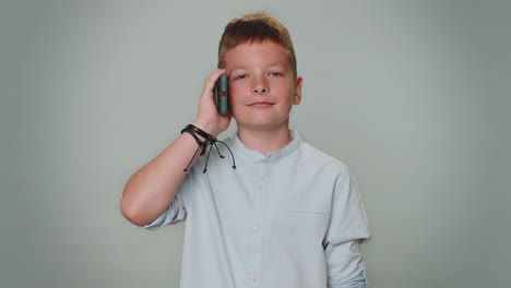 toddler kid boy having pleasant mobile conversation using smartphone with friends telling good news