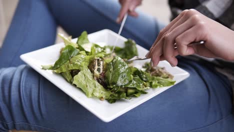 Close-up-footage-of-a-young,-attractive-woman-enjoys-her-delicious-food.-Casual-clothes.-Indoors