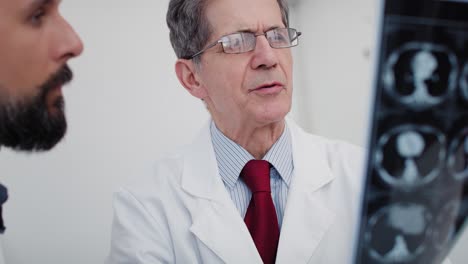 Handheld-view-of-two-busy-doctors-discussing-some-medical-records