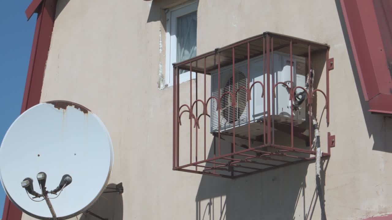aire acondicionado montado en la pared de la casa y protegido por una jaula metálica. equipo para el aire acondicionado en las habitaciones.