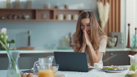 Surprised-businesswoman-using-laptop-at-kitchen