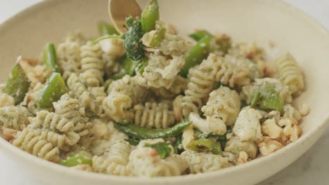 persona irreconocible comiendo pasta del plato