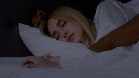 couple in bed, one checking phone