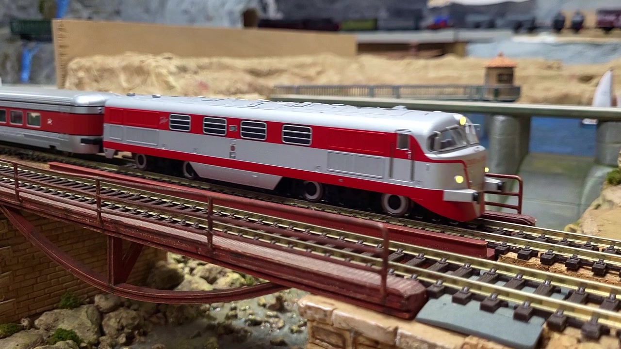 Modelleisenbahnen in Bewegung, die über eine Brücke fahren. Eisenbahnmodellbau. Modell eines TALGO-Zuges in Bewegung.