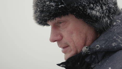 profile of middle age man in warm clothes on freezing cold snowy day