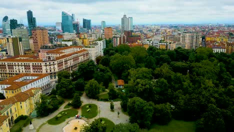 4k aerial drone video of high rise apartment buildings and modern skyscrapers near indro montanelli garden park in milan, italy on a summer day