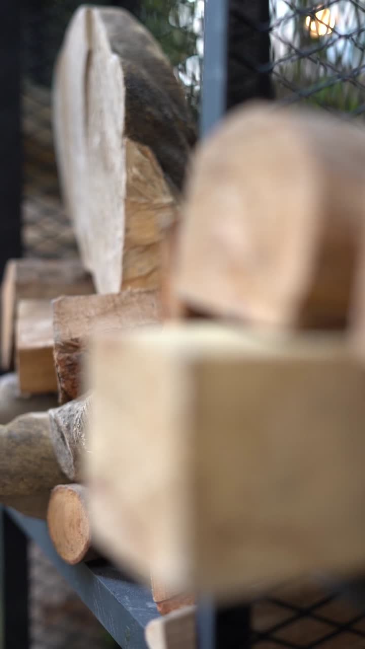 A view of rustic wooden log slice placed on top of other wood pieces, showing natural grain texture and rough edges, close up shot