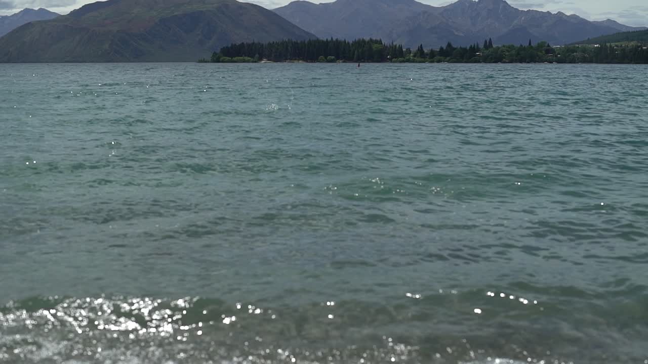 퀸스타운에 있는 와카티푸 호수의 깨끗한 물을 기울입니다.