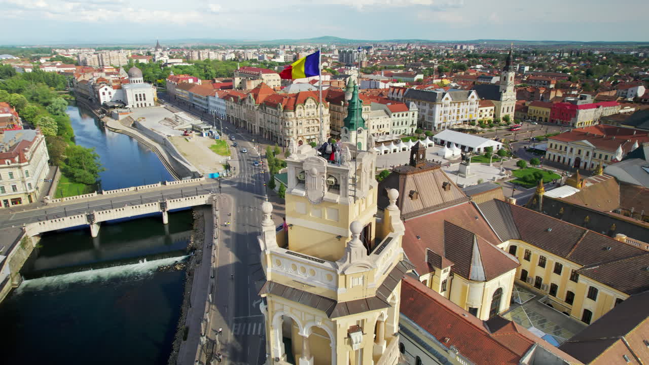 Аэрофотосъемка башни мэрии в центре города Орадя, Румыния. Люди на вершине башни, расположенной на площади Объединения.