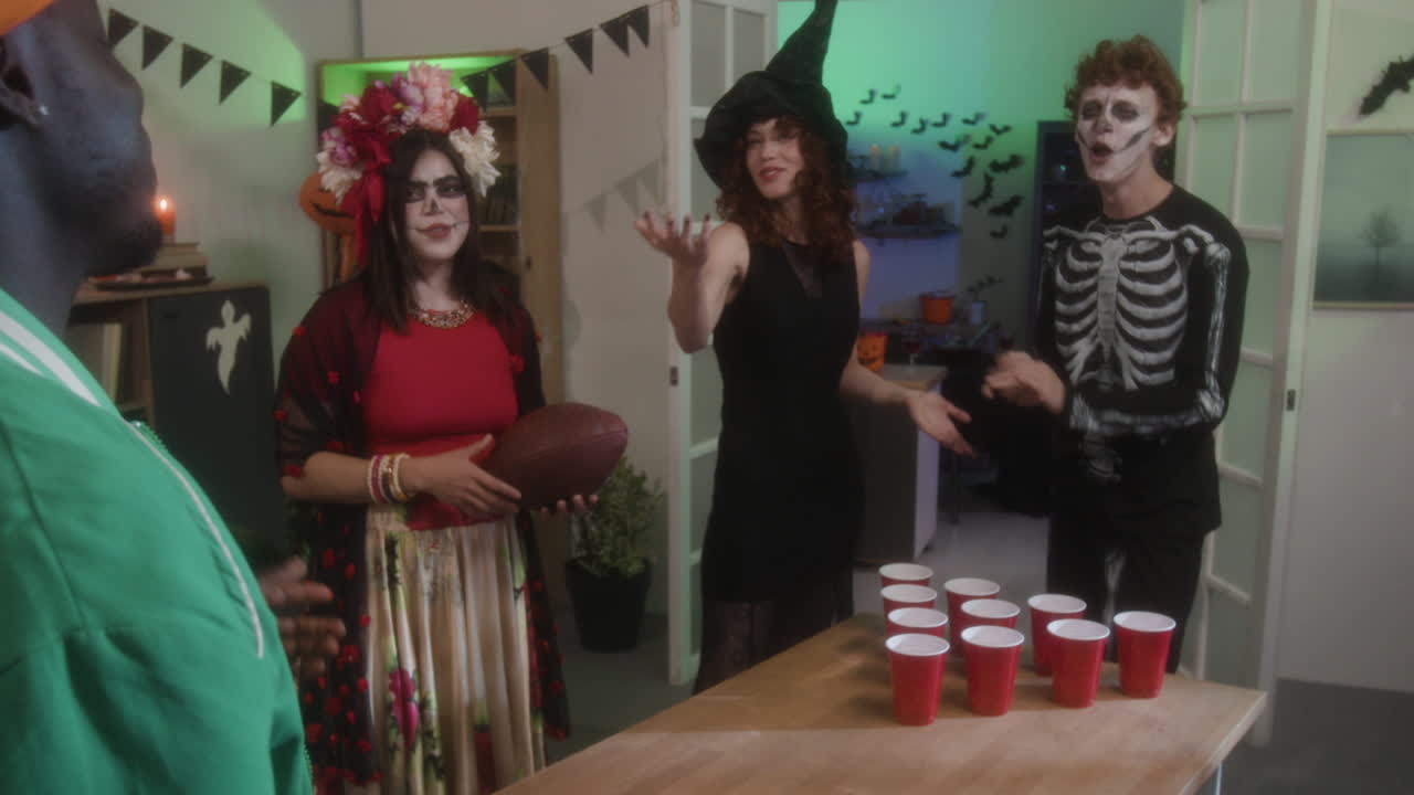 Halloween Party with Costumed Guests Playing Beer Pong