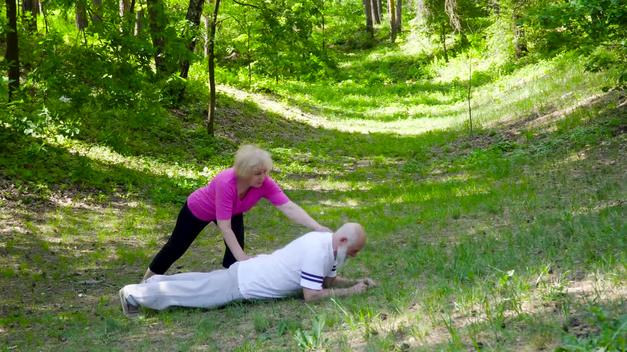 고령 여성은 남편을 잔디에 스포츠 운동을 할 수 있도록 hekp