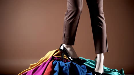 mannequin legs in high heels on a pile of colorful fabrics