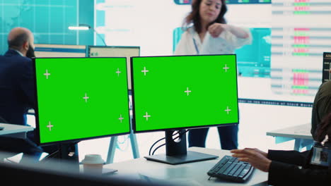 Executive-officer-analyzing-greenscreen-on-monitors-at-his-workstation