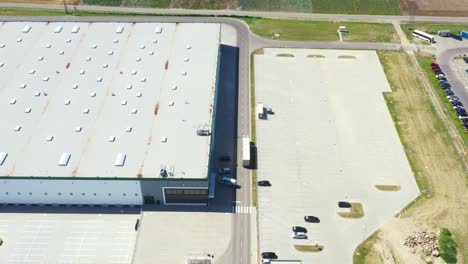 Luftaufnahme-Der-Laderampe-Eines-Industrielagers,-Wo-Viele-Lastwagen-Mit-Sattelaufliegern-Waren-Laden