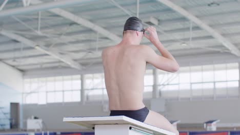 swimmer taking off his pool goggles