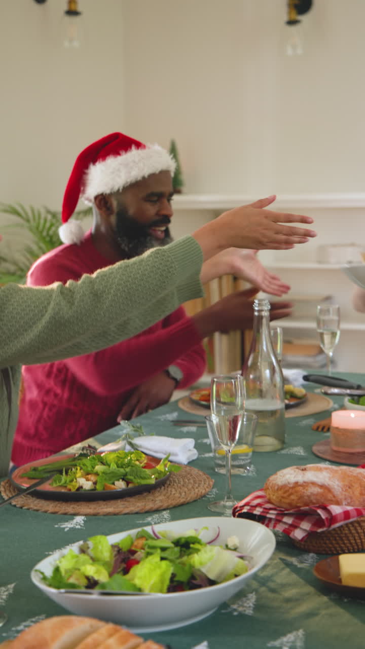 Vertical video: Family sharing Christmas meal at home, passing salad, enjoying holiday together