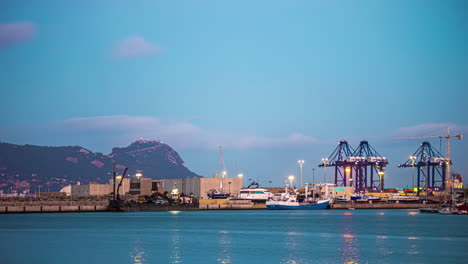 Timelapse-Del-Amanecer-De-Las-Grúas-Portuarias-Trabajando-En-El-Puerto-De-Algeciras,-Cádiz,-España