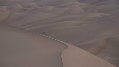 panorámica hasta la impresionante cordillera detrás del campo de dunas de arena al amanecer