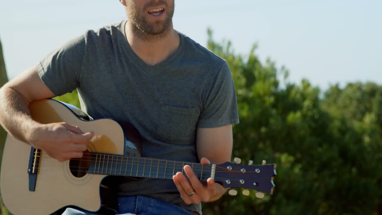 ⁇ 은 날에 기타를 연주하는 중장년 백인 남자의 앞면 4k