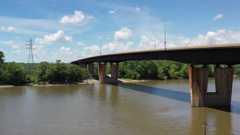 aerial view of a metal bridge and power lines spanning the river bed