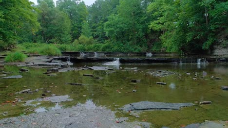 imágenes de drones sobre el lecho de un río con cinco cascadas en el fondo