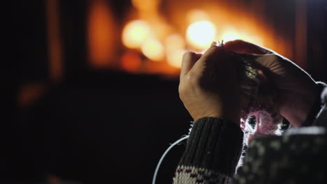 Woman-Handicrafts-By-The-Fireplace-Knits-Warm-Clothes