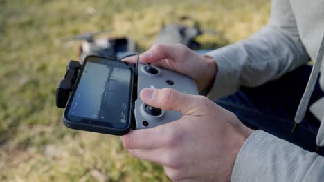 Side-angle-of-man-flying-drone-with-remote-controller-and-screen