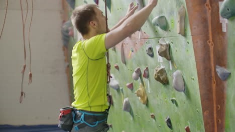 climber attaching a belay rope and chalking hands.