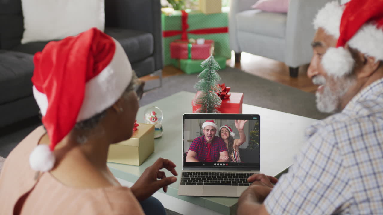 feliz pareja afroamericana senior en videollamada en computadora portátil pareja caucásica en tiempo de navidad