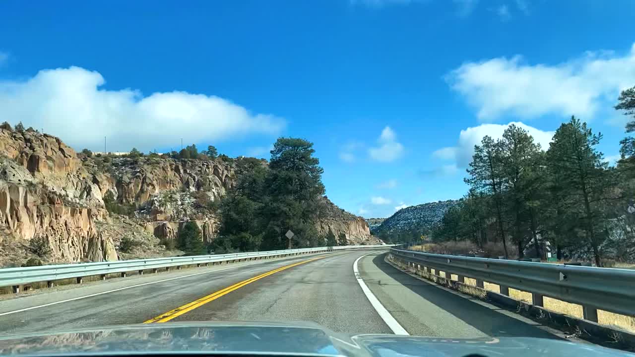 Timelapse of car driving through mountains on curvy road in autumn with snow