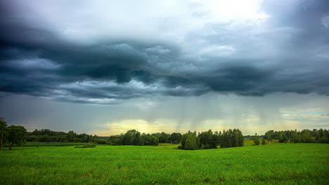 rain clouds slide over a green landscape with trees and meadows