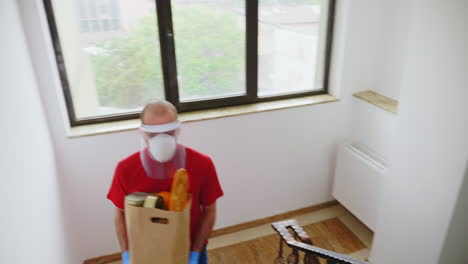Food courier with groceries wearing mask