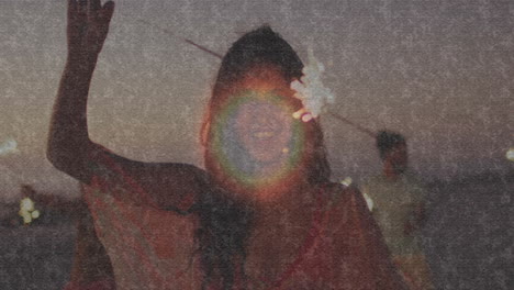 holding sparklers, woman celebrating on beach during sunset with joyful animation