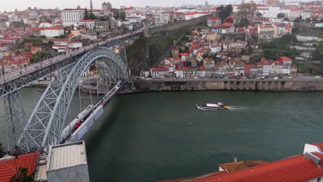 Vista-Aérea-De-Un-Barco-En-El-Río-Duero-Cerca-Del-Puente-Luis-I-En-Un-Día-Pintoresco-En-Portugal