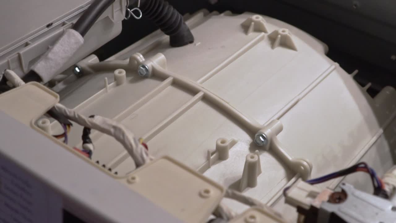 Close up at the interior mechanism of washing machine while it's working Slow motion 100fps