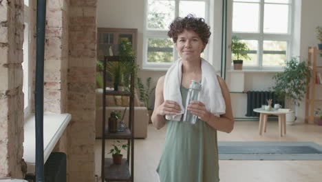 woman with water bottle in home gym