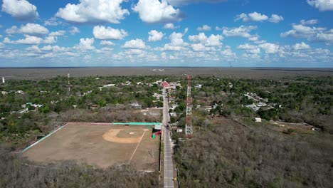 Toma-Aérea-Hacia-Atrás-De-La-Iglesia-Y-El-Campo-De-Béisbol-En-Tahmek-Yucatan-Mexico