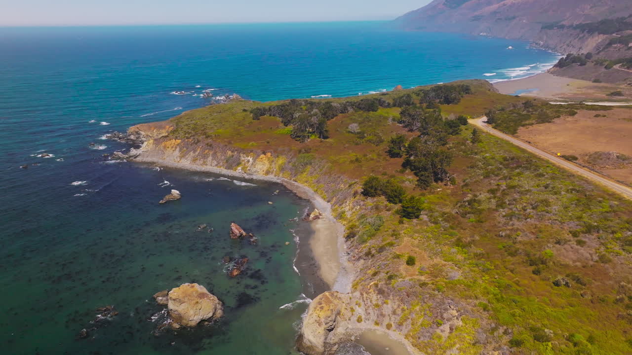 Rocky beach covered with moss, lichen and few bushes. Amazing coastline of Pacific at Morro Bay, California, USA. Aerial view.